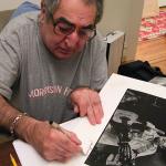 Jim Marshall signs his iconic Johnny Cash print for Brad Mangin in his San Francisco home on February 11, 2009. (Photo by Grover Sanschagrin) Jim Marshall signs his iconic Johnny Cash print for Brad Mangin in his San Francisco home on February 11, 2009. (Photo by Grover Sanschagrin)